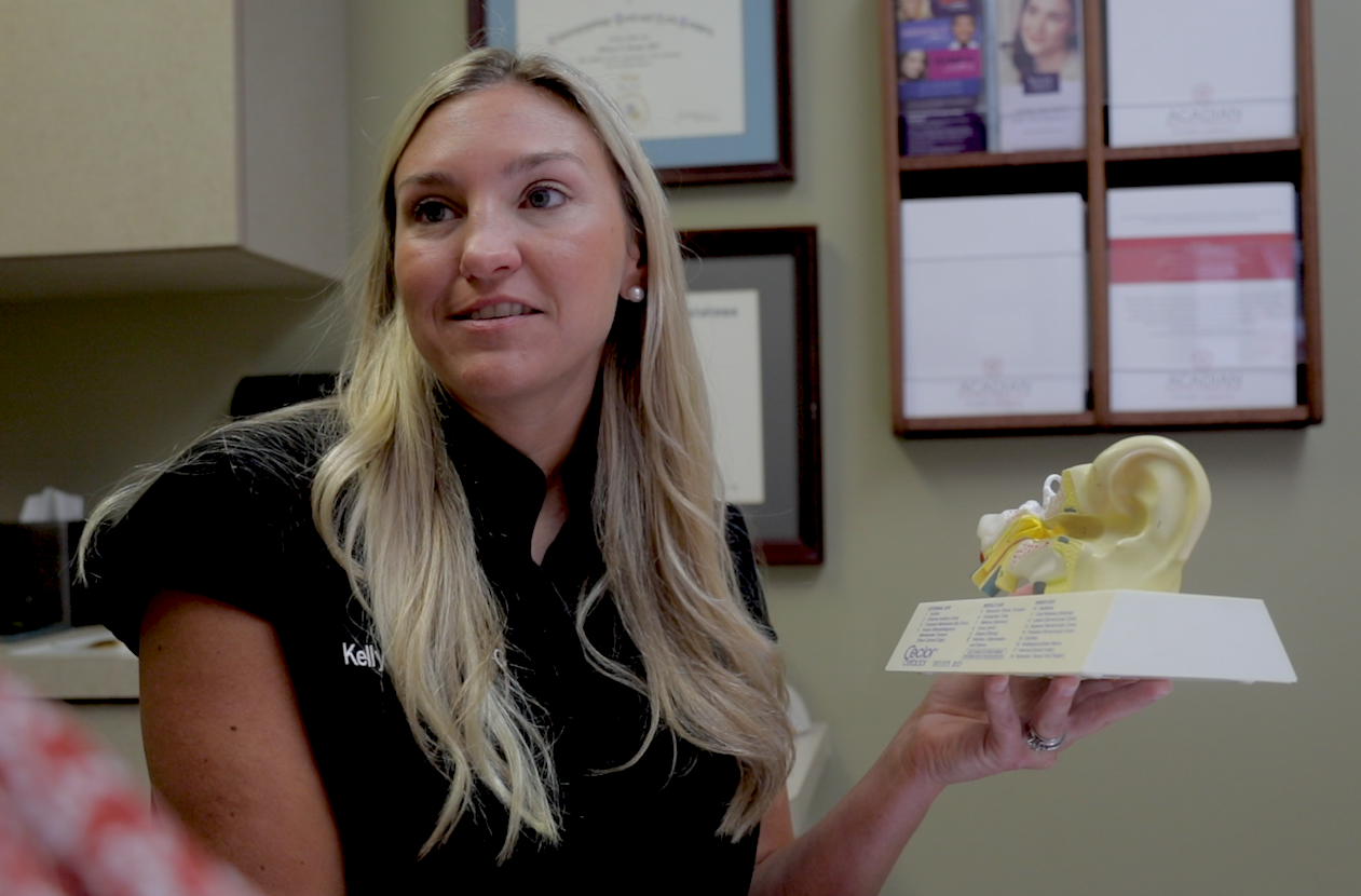 Nurse practitioner Kelly Harmon uses a visual aid to describe the inner ear canal to a patient. Harmon earned her MS in Nursing online from UL Lafayette.